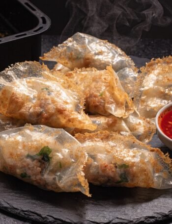Can you cook rice paper dumplings in an air fryer? recipe hero presentation - Stunning photorealistic hero shot of crispy golden rice paper dumplings cooked in an air fryer, serv