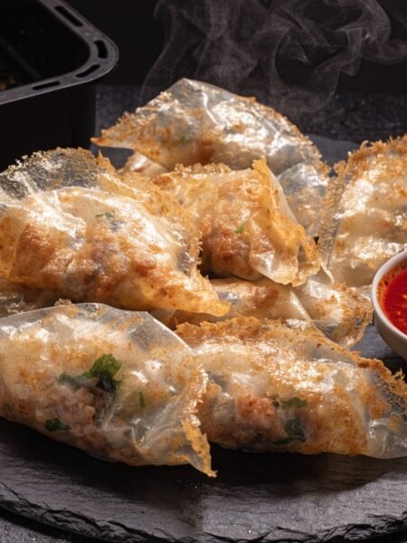 Can you cook rice paper dumplings in an air fryer? recipe hero presentation - Stunning photorealistic hero shot of crispy golden rice paper dumplings cooked in an air fryer, serv