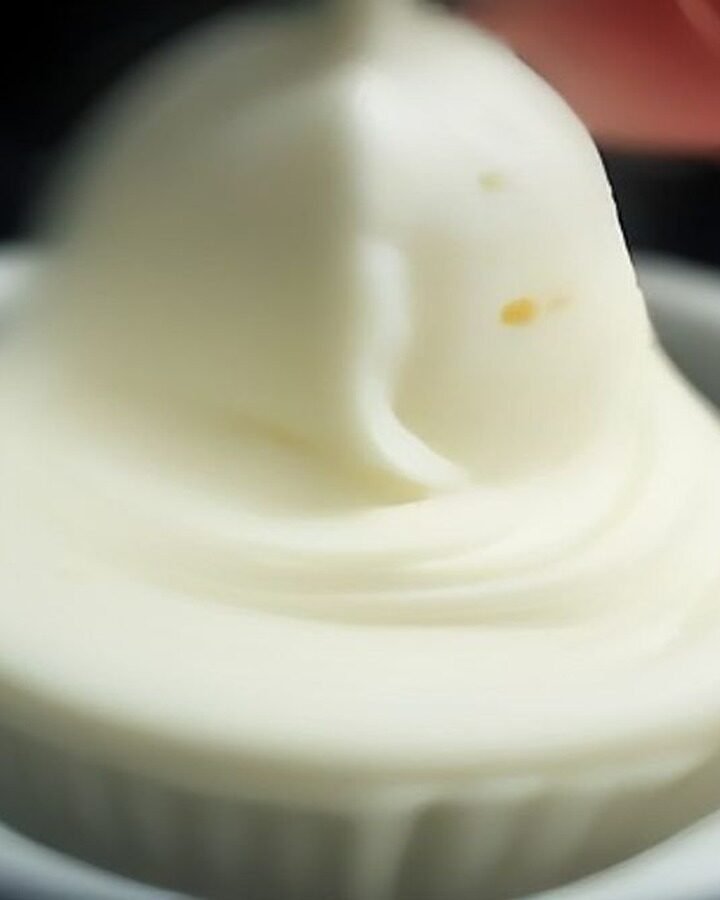 How to Store Buttercream Without Losing Texture cooking process - Macro photograph of a stand mixer paddle attachment mixing creamy buttercream, capturing air pockets