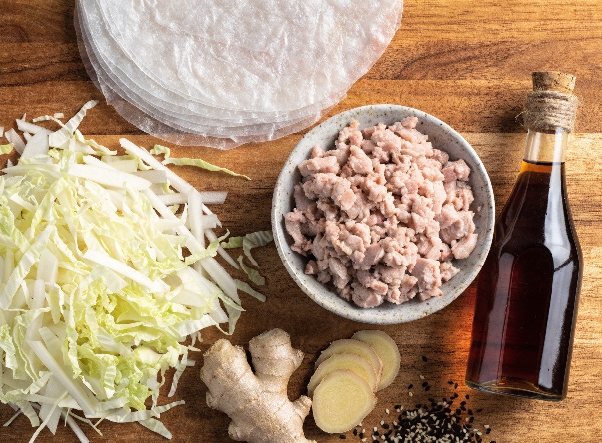 What is the best filling for rice paper dumplings? preparation close-up - Beautifully organized flatlay of ingredients including round rice paper sheets, minced pork, cabbage