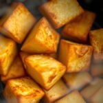 Can you air fry tofu directly from frozen? recipe hero presentation - Photorealistic close-up of golden crispy air-fried tofu cubes in an air fryer basket with steam risi