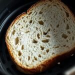 Can you put frozen bread directly into an air fryer? recipe hero presentation - A close-up photorealistic food photography shot of a single frozen slice of sourdough bread resting