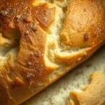 What temperature should I use to thaw bread in an air fryer? recipe hero presentation - A close-up photorealistic shot of a golden artisanal loaf of bread inside a modern black air fryer b