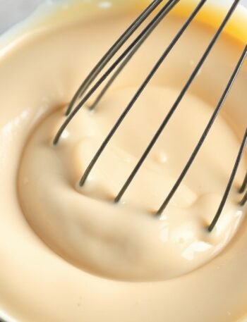 How long does it take to prepare runny no bake cheesecake filling? recipe hero presentation - Close up of smooth no bake cheesecake filling in a glass bowl with a whisk